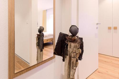 a mirror on a wall with a woman in a room at Jolimont Apartments in Zermatt