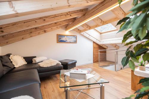 a living room with a black couch and a table at Jolimont Apartments in Zermatt