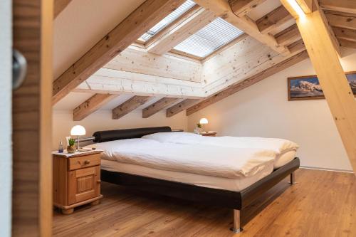 ein Schlafzimmer mit einem großen Bett und einem Dachfenster in der Unterkunft Jolimont Apartments in Zermatt
