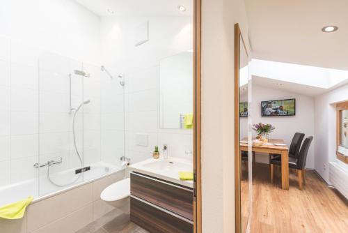 a bathroom with a tub sink and a toilet and a table at Jolimont Apartments in Zermatt