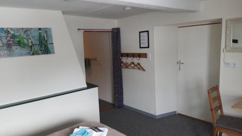 a room with a white wall and a door at La Fermette Blanche in Nadrin