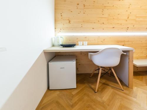 a white desk and a chair in a room at Kamr’ca in Ljubljana