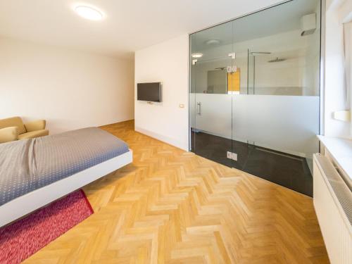 a bedroom with a bed and a glass shower at Kamr’ca in Ljubljana