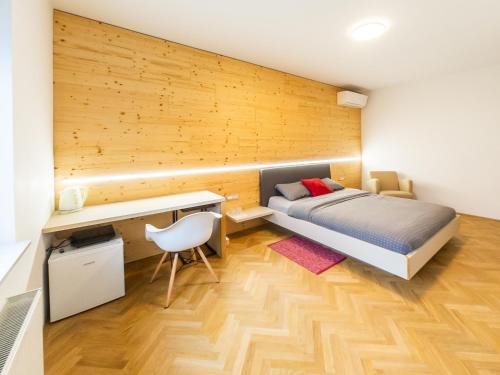 a small bedroom with a bed and a desk at Kamr’ca in Ljubljana