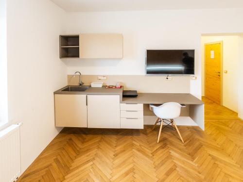 a kitchen with a sink and a desk with a chair at Kamr’ca in Ljubljana
