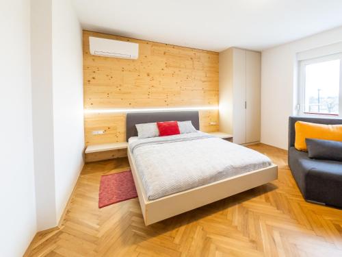 a bedroom with a bed and a couch at Kamr’ca in Ljubljana