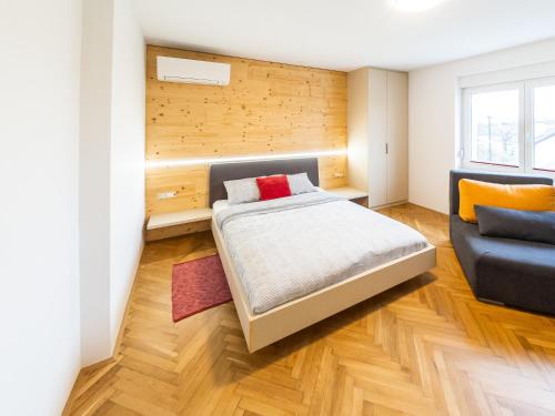 a bedroom with a bed and a couch at Kamr’ca in Ljubljana