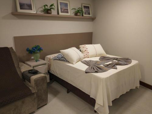 1 dormitorio con 1 cama y 1 silla en Residence Farol - Loft 219, en Laguna