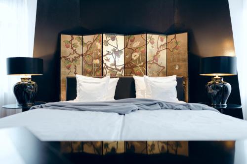 ein Schlafzimmer mit einem großen Bett mit zwei Lampen in der Unterkunft Hotel Bamberger Hof Bellevue in Bamberg