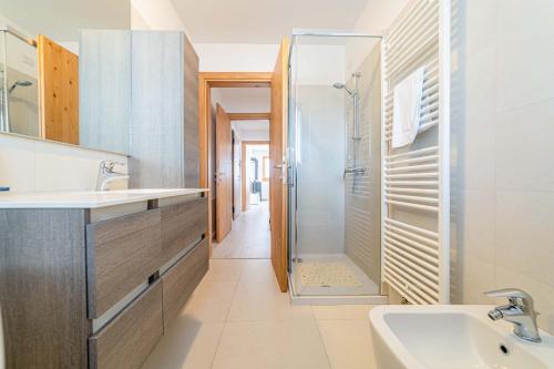 ein Bad mit einem Waschbecken und einer Dusche in der Unterkunft Olivia Home in Caprile