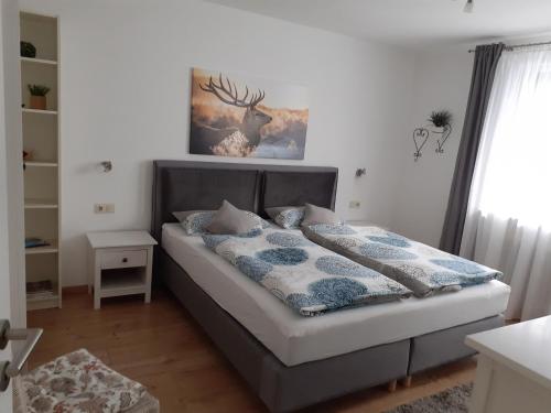 una camera da letto con un letto con un disegno di cervo sul muro di Ferienwohnung Tonbachtal a Baiersbronn