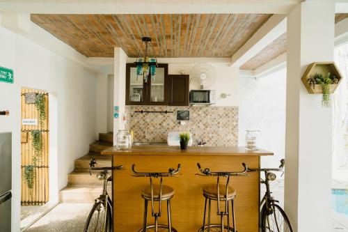 a kitchen with a bar with two stools at Otu Hostel By Ostic in Yogyakarta