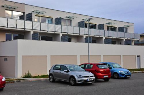 three cars parked in a parking lot in front of a building at Relax apartmán Třeboň in Třeboň