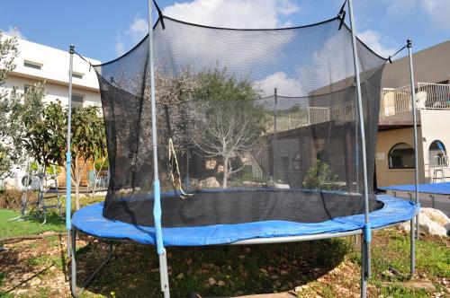 a trampoline with a net in a yard at Shmulik Galilee in Lavon