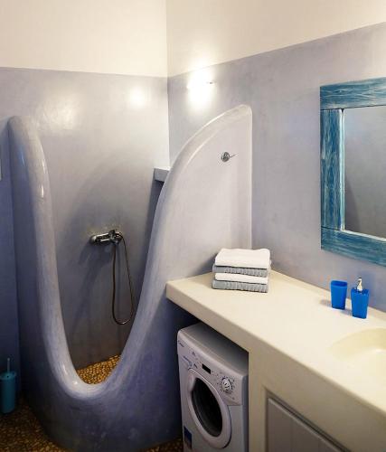 a bathroom with a sink and a shower with a mirror at Flora Apartments in Drios