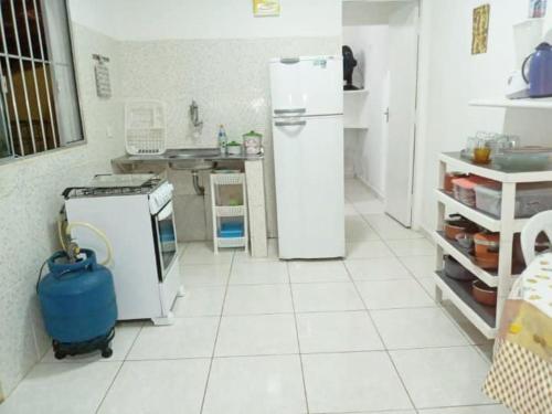 a white kitchen with a refrigerator and a stove at Chalés Boraceia Duda in Boracéia