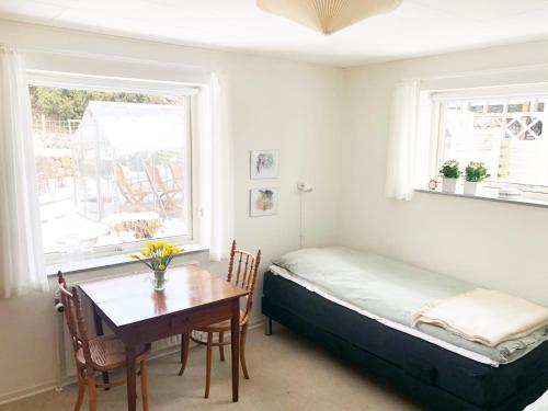 Schlafzimmer mit einem Bett, einem Tisch und einem Fenster in der Unterkunft Kirkevængets mini Bed and Breakfast in Kruså