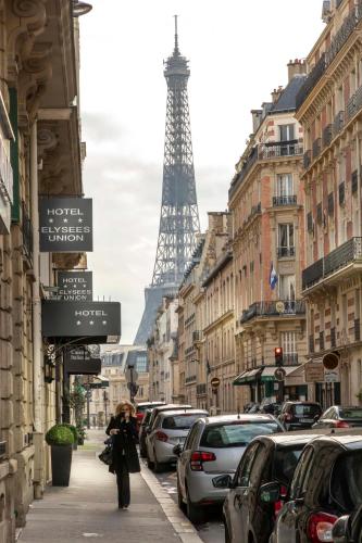 a woman walking down a street with the eiffel tower at Elysées Union in Paris