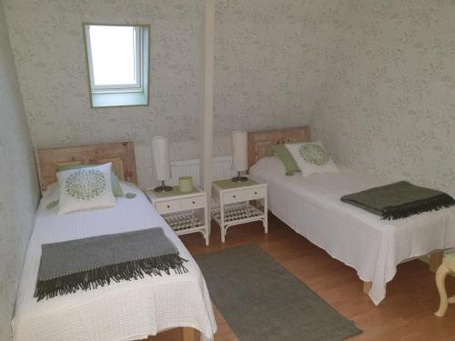 um quarto com duas camas e uma janela em Marsjö Gård Bo & Yoga vandrarhem em Borgholm