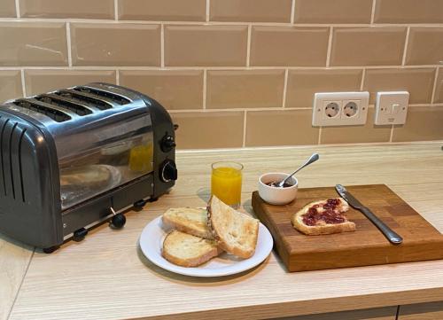 einen Toaster und Toast auf einer Theke mit einem Teller Brot in der Unterkunft Casa Camino Turismo Rural in Palas de Rei