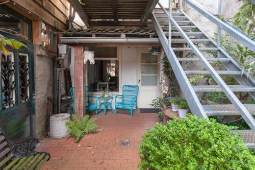 a patio with blue chairs and a table and stairs at De Stadsboerderij in Kampen