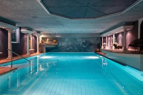 a large swimming pool in a building at Hotel Eden Wellness in Zermatt