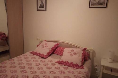 a bed with pink and white sheets and pillows at La faurie in Soubran