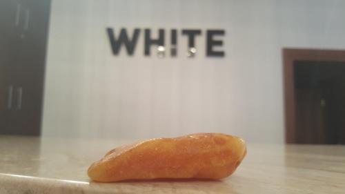 a donut sitting on a table in front of a white sign at Hotel White in Krynica Morska