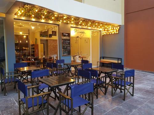 a restaurant with tables and blue chairs and lights at Departamenos Llanos in Termas de Río Hondo