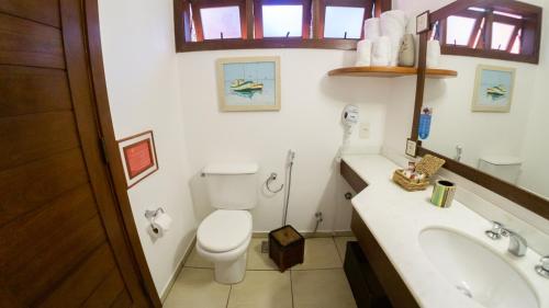 uma casa de banho com um WC branco e um lavatório. em Azeda Boutique Hotel em Búzios