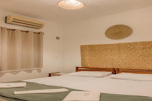A bed or beds in a room at Pousada Migo