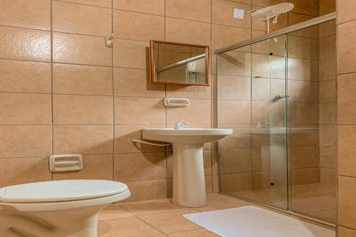 y baño con aseo, lavabo y ducha. en Pousada Migo, en Porto Seguro