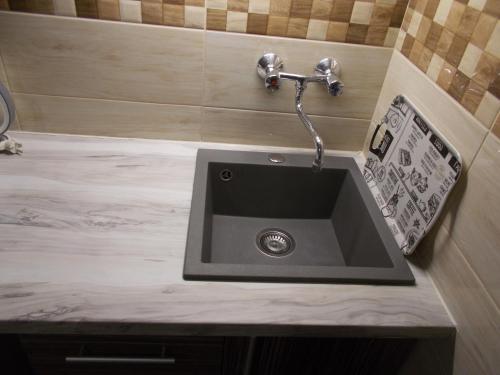 a sink in a bathroom with a marble counter top at Green Szálláshely in Debrecen