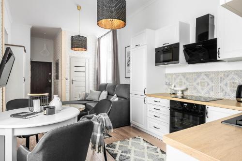 a kitchen and living room with a table and chairs at Apartament Biała Perła in Czarny Dunajec