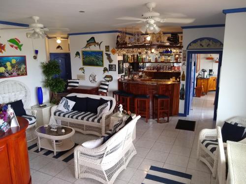 una sala de estar con sillas y un bar en Drake Inn, en Puerto Villamil