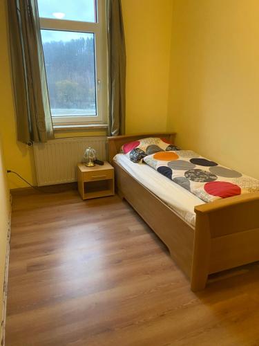 ein kleines Schlafzimmer mit einem Bett und einem Fenster in der Unterkunft Ferienwohnung Goldener Drache in Adorf