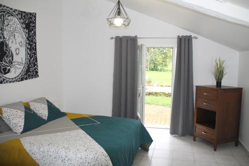 a bedroom with a bed and a dresser and a window at RUDELLE in Thénac