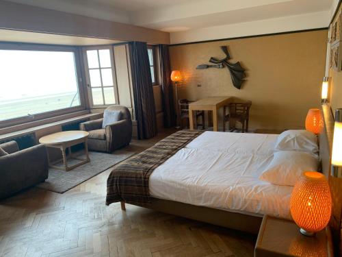 a hotel room with a bed and a large window at Hotel Villa Escale in De Panne