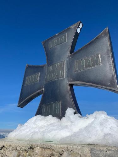 a metal cross on top of a pile of snow at Ferienwohnung Unsere Mühle in Kirchbach