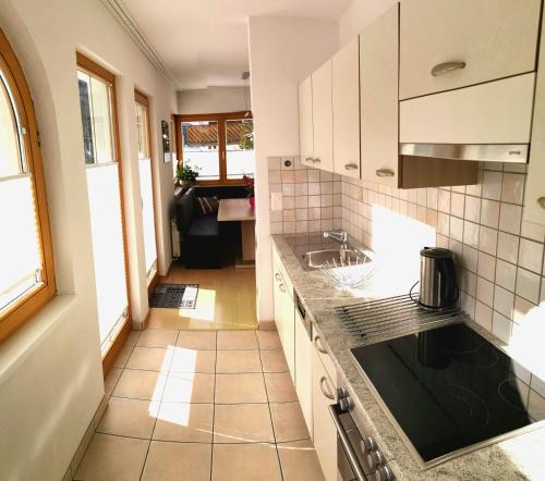 a kitchen with white cabinets and a tile floor at Apart Montanara in Samnaun