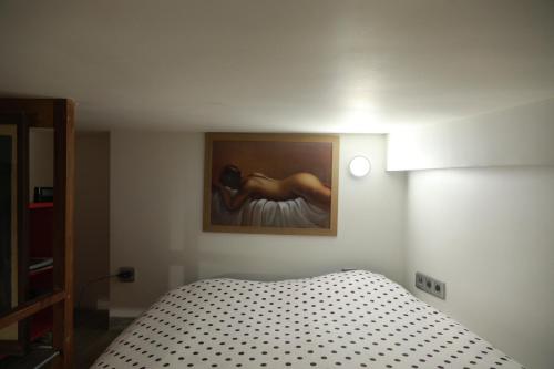 une chambre avec un lit avec un tableau sur le mur dans l'établissement PARISIEN Espace, à Paris