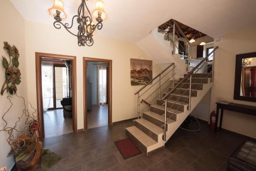 a staircase in a living room with a chandelier at Gallis Villa in Pefkias