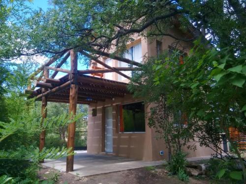 a house with a wooden roof at Casa La Toma in Capilla del Monte