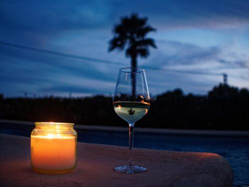 a glass of wine and a candle on a table at Villa Mi Sueño - Pool⎜BBQgrill⎜Fast Internet⎜Workspace in Benissa