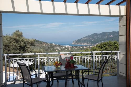 a table on a balcony with a view of the ocean at Gallis Villa in Pefkias