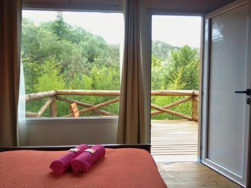 a pair of purple socks on a bed in front of a window at Casa La Toma in Capilla del Monte
