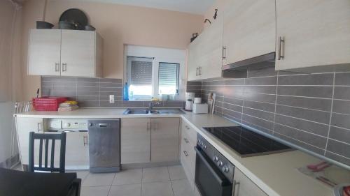 a kitchen with white cabinets and a sink at Christina Apartment in Derveni