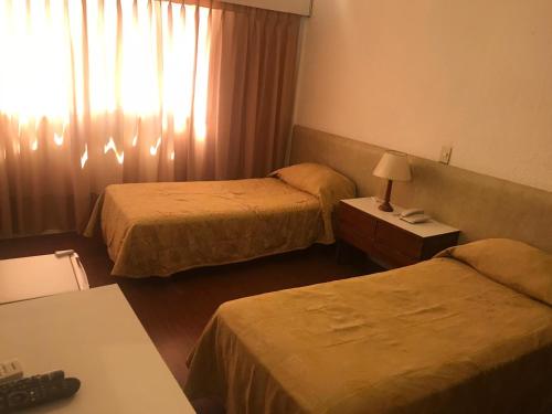 a hotel room with two beds and a window at Punta del Este Shelton Hotel in Punta del Este