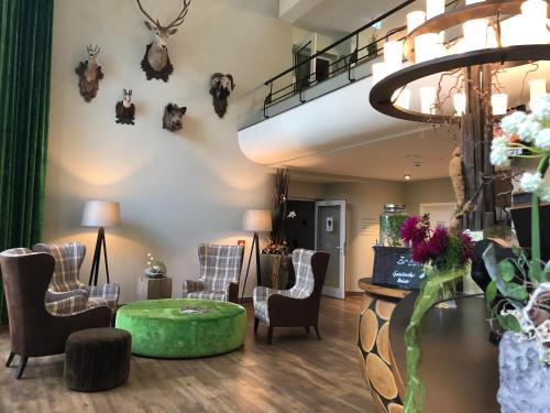 a waiting room with chairs and a table and a staircase at BERG & SPA HOTEL GABELBACH in Ilmenau