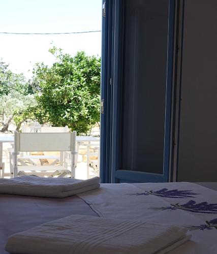 a bedroom with a bed and a window with a chair at Flora Apartments in Drios
